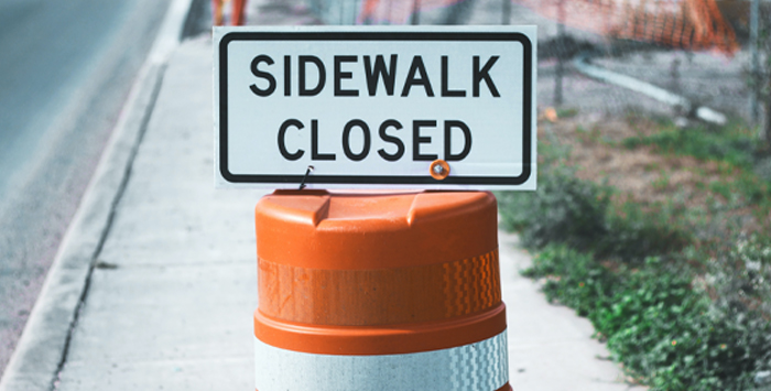 A photo of a sign that says Sidewalk Closed